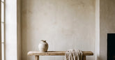 Salon wabi sabi avec mur en plâtre banc en bois brut et céramique artisanale