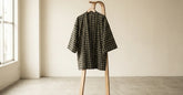 Haori japonais à motif géométrique suspendu dans une pièce claire et épurée
