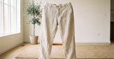 Pantalon ample homme en lin écru présenté dans un intérieur clair et lumineux
