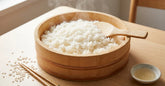 Riz a sushi brillant dans un hangiri en bois avec spatule shamoji et baguettes sur table