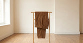 Pantalon homme en velours côtelé brun présenté dans un intérieur clair et sobre