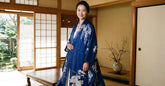 Femme elegante portant une veste kimono bleue a motifs floraux dans un interieur japonais traditionnel