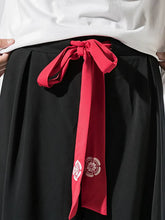 Détail du pantalon hakama homme Kōsei noir avec ceinture japonaise rouge nouée, finition soignée et symbole floral inspiré du Japon.