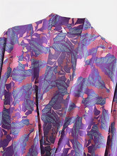 Détail du tissu de l’Ensemble Kimono Femme Éclat Violet – motifs floraux et feuillages roses et bleus sur fond violet, texture fluide et élégante.