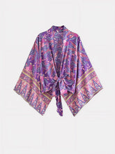Veste de l’Ensemble Kimono Femme Éclat Violet – manches larges, nœud à la taille et bordures décoratives aux motifs floraux violets et roses.