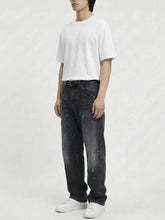 Pantalon baggy homme Kuro Classic noir, coupe large en denim avec effet légèrement usé, vu de trois-quarts, porté avec t-shirt blanc ample et sneakers blanches sur fond blanc, style urbain décontracté.
