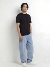 Pantalon baggy streetwear japonais Tokyo Blue pour homme, coupe ample style urbain japonais, porté avec t-shirt noir sur fond blanc