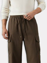 Vue rapprochĂ©e dâun homme portant un pantalon japonais cargo en coton avec cordon ajustable et poches latĂ©rales.