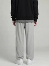 Dos du pantalon japonais droit gris clair pour homme, coupe fluide et ample, détail de la poche arrière, présentation en studio