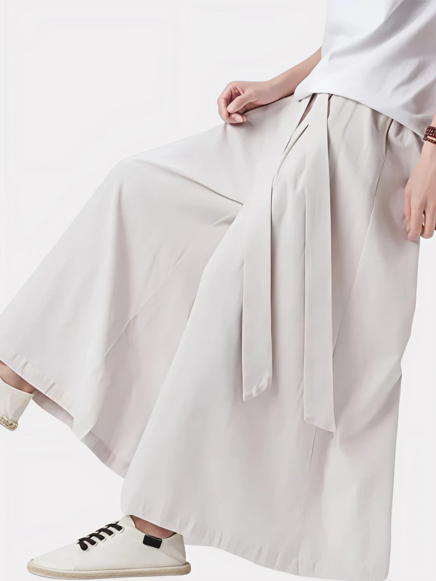 Homme assis portant un pantalon japonais beige, tissu doux et confortable idéal pour la détente et la méditation.