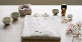 Kimono de plage clair et petits cadeaux japonais posés sur une table claire