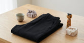 Pantalon japonais homme et accessoires cadeaux disposés sur une table en bois