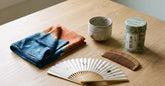 Sélection de cadeaux japonais pour femme disposés sur une table en bois clair