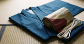 Kimono japonais et obi disposés à plat prêts à être enfilés sur un tatami