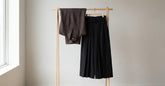 Hakama homme noir plissé présenté sur un support en bois dans une pièce claire