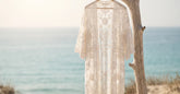 Kimono de plage en dentelle blanche suspendu face à la mer en été