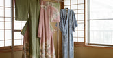 Kimono en soie et yukata en coton présentés côte à côte sur des porte-kimonos en bois
