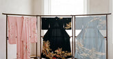 Trois kimonos formels japonais alignés sur des supports en bois dans une pièce claire