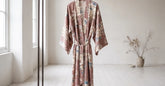 Robe kimono fluide à motifs floraux présentée sur un portant dans un intérieur clair