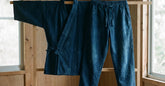 Samue japonais indigo veste et pantalon présentés dans un intérieur en bois clair