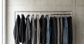 Portant de streetwear japonais noir et gris devant un mur en béton clair