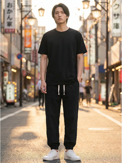 Pantalon japonais Kaito noir porte en ville, homme dans une rue japonaise au coucher du soleil