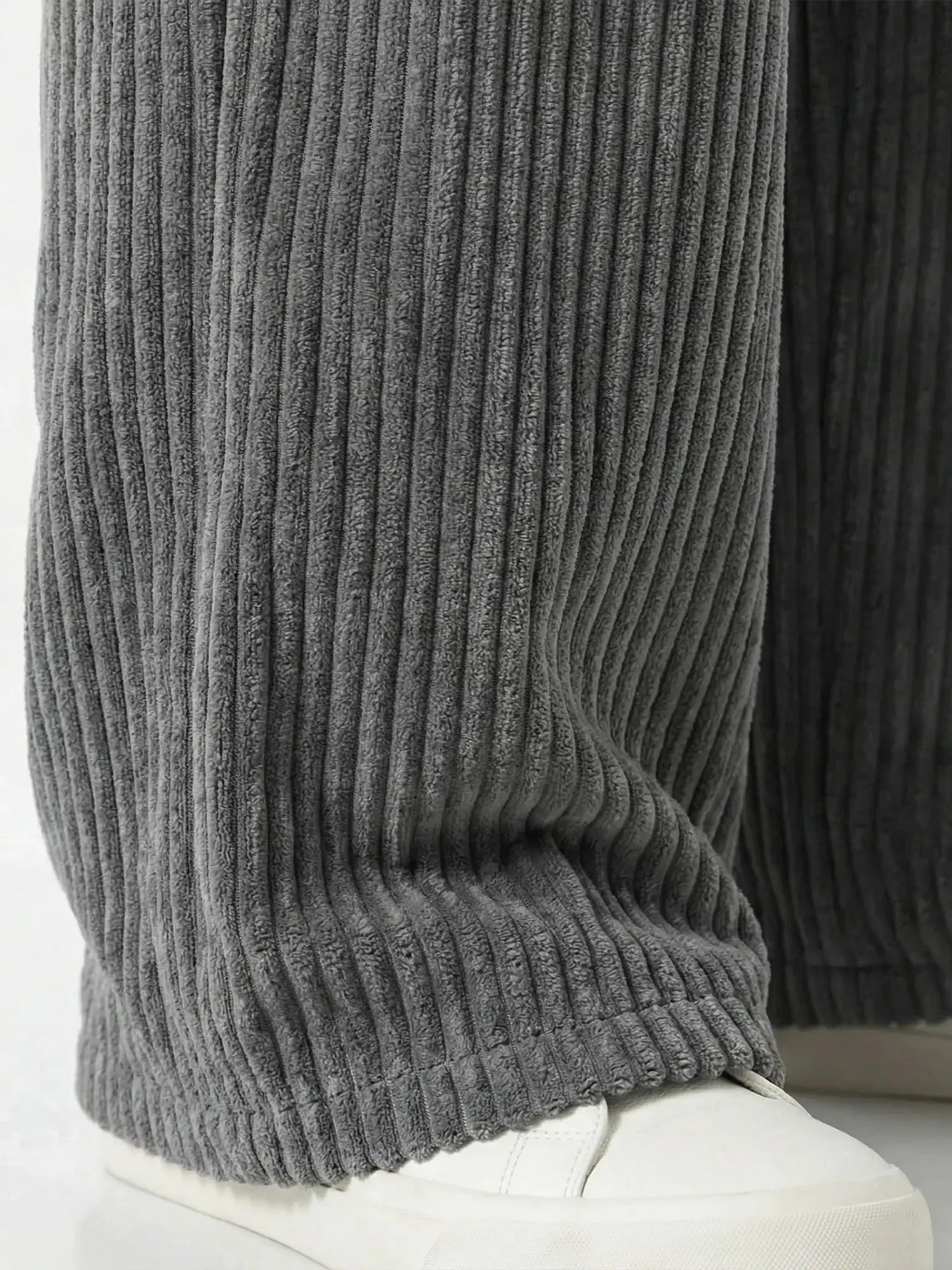 Zoom sur le bas de jambe du pantalon japonais homme Akeno, tissu plissé vertical gris anthracite, coupe ample fluide au niveau de la cheville