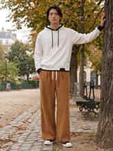 Pantalon japonais homme Akeno porté dans un parc, coupe ample plissée marron, taille élastique avec cordon, style japonais urbain naturel en extérieur