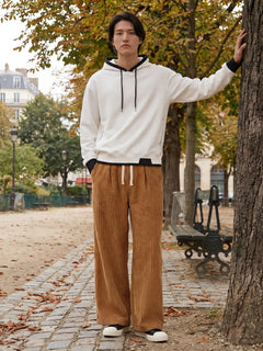 Pantalon japonais homme Akeno porté dans un parc, coupe ample plissée marron, taille élastique avec cordon, style japonais urbain naturel en extérieur