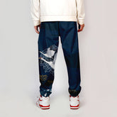 Pantalon japonais bleu pour homme avec motif de grue blanche, coupe ample et élastique aux chevilles, style Seigaiha inspiré des arts traditionnels.