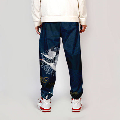 Pantalon japonais bleu pour homme avec motif de grue blanche, coupe ample et élastique aux chevilles, style Seigaiha inspiré des arts traditionnels.
