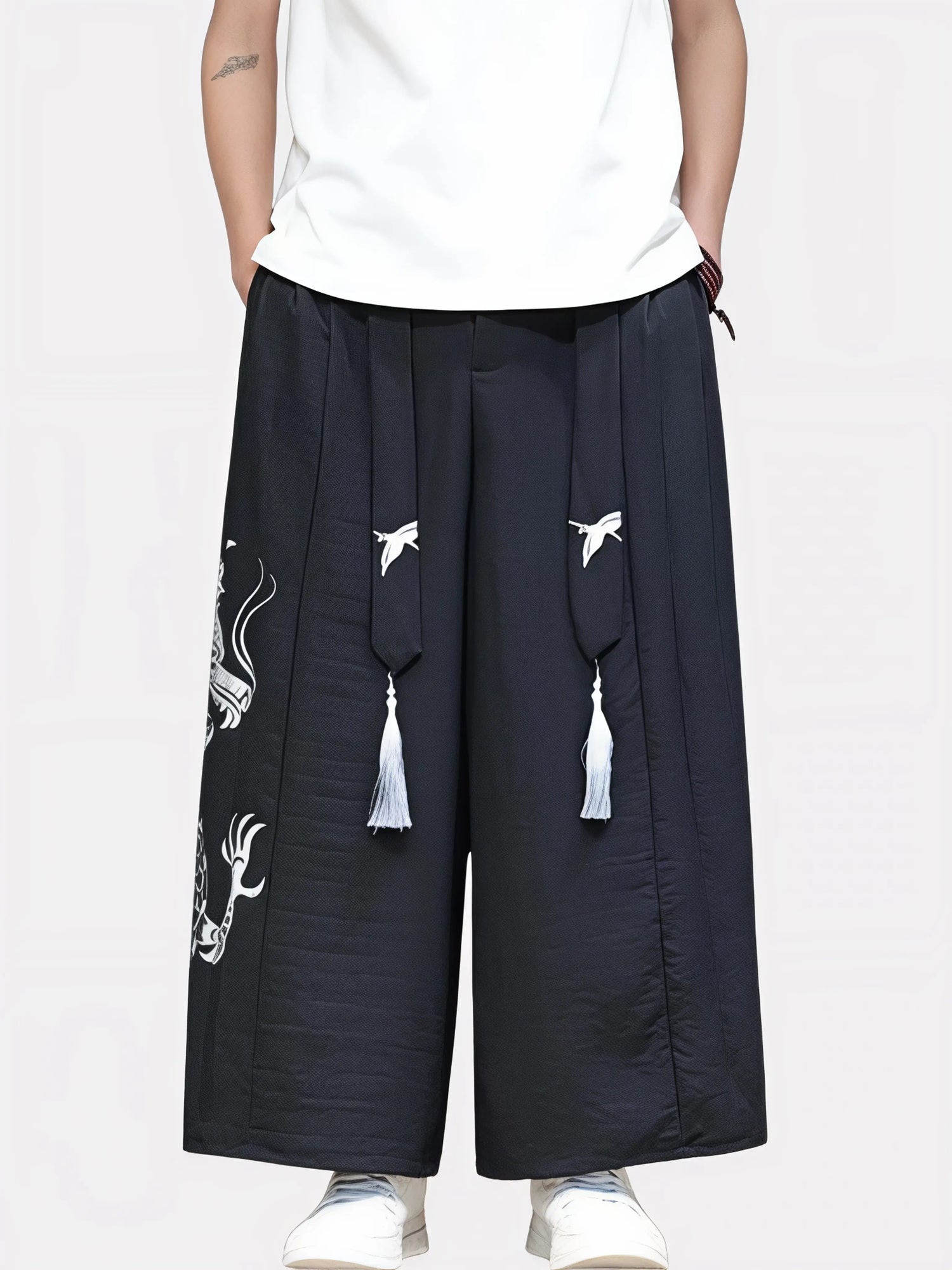 Vue de face du pantalon kimono noir pour homme, coupe fluide, tissu léger et broderie dragon argenté.