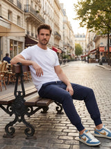 Jogging japonais homme Kage porté assis sur un banc dans une rue parisienne, style urbain et coupe confortable