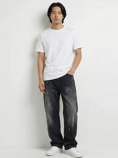 Pantalon baggy homme Kuro Classic noir, coupe large et décontractée, denim effet légèrement usé, porté avec t-shirt blanc et sneakers blanches sur fond blanc, style urbain minimaliste.