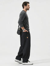 Pantalon casual japonais noir pour homme vu de profil, coupe large fluide au style minimaliste inspiré du Japon