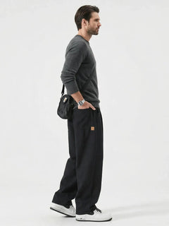 Pantalon casual japonais noir pour homme vu de profil, coupe large fluide au style minimaliste inspiré du Japon