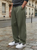 Pantalon casual japonais vert kaki pour homme, coupe large fluide au style minimaliste, porté en milieu urbain