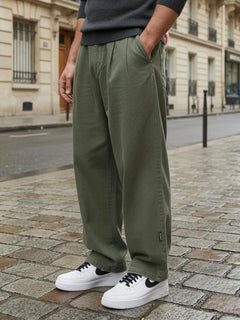 Pantalon casual japonais vert kaki pour homme, coupe large fluide au style minimaliste, porté en milieu urbain