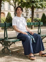 Pantalon hakama homme Kōsei bleu marine porté en extérieur, pantalon japonais large et fluide avec ceinture assortie, style minimaliste inspiré du Japon.