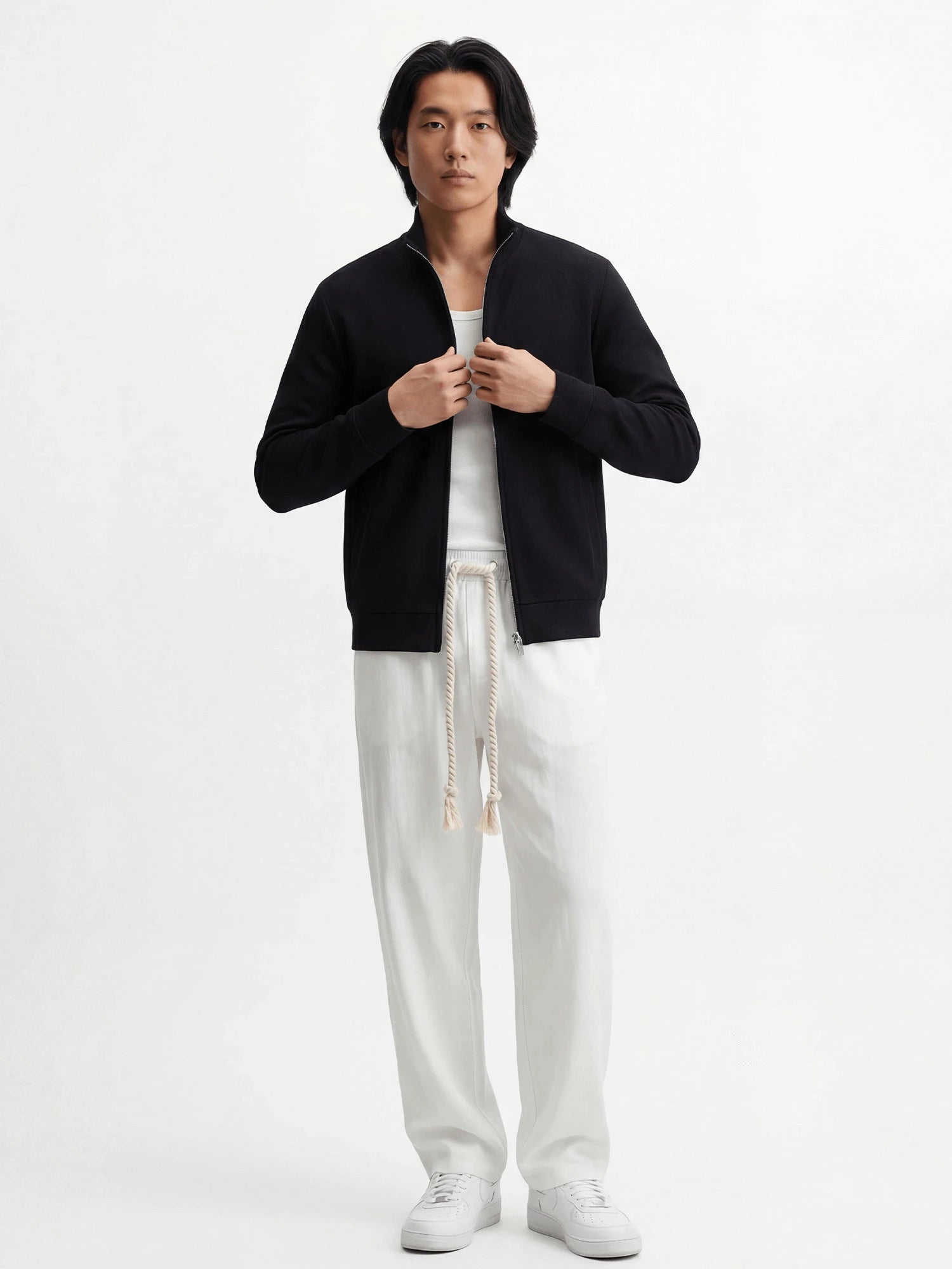 Pantalon homme japonais Natsu blanc, coupe fluide et confortable avec taille élastique et cordon, porté avec débardeur blanc, veste noire zippée et sneakers blanches sur fond blanc, style minimaliste et moderne.
