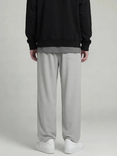 Dos du pantalon japonais droit gris clair pour homme, coupe fluide et ample, détail de la poche arrière, présentation en studio