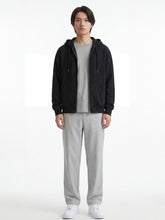 Pantalon japonais droit gris clair pour homme, silhouette fluide et minimaliste, porté de face avec hoodie noir et sneakers blanches sur fond studio