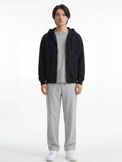 Pantalon japonais droit gris clair pour homme, silhouette fluide et minimaliste, porté de face avec hoodie noir et sneakers blanches sur fond studio
