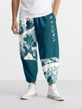 Homme portant le pantalon japonais Élite Vagues, vue de face avec motif vague Hokusai et coupe ample resserrée aux chevilles.