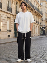 Pantalon japonais homme Hikari noir porté dans une rue parisienne, pantalon cargo ample style streetwear japonais