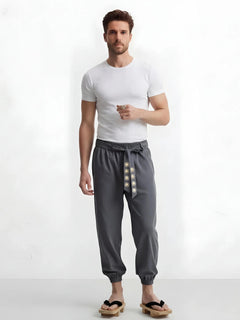Pantalon japonais homme Kaizen gris, coupe ample inspirée du vêtement traditionnel japonais, porté avec t-shirt blanc et geta