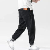 Pantalon japonais homme Kenji noir vu de dos, coupe ample et moderne en velours côtelé avec étiquette orange, style japonais contemporain.