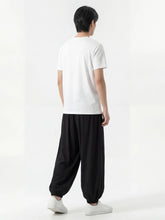 Pantalon japonais homme Kurozen noir vu de dos, coupe ample style hakama moderne, porté avec t-shirt blanc et sneakers sur fond blanc