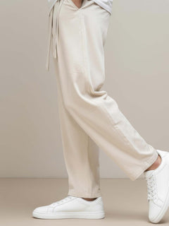 Détail du pantalon japonais homme Zenkai beige, tissu fluide à coupe large, finition soignée au bas de jambe