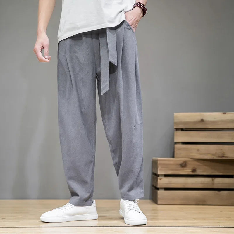Pantalon japonais homme Zenkai gris à coupe large, taille ajustable avec lien, style minimaliste japonais, porté en studio sous un angle différent
